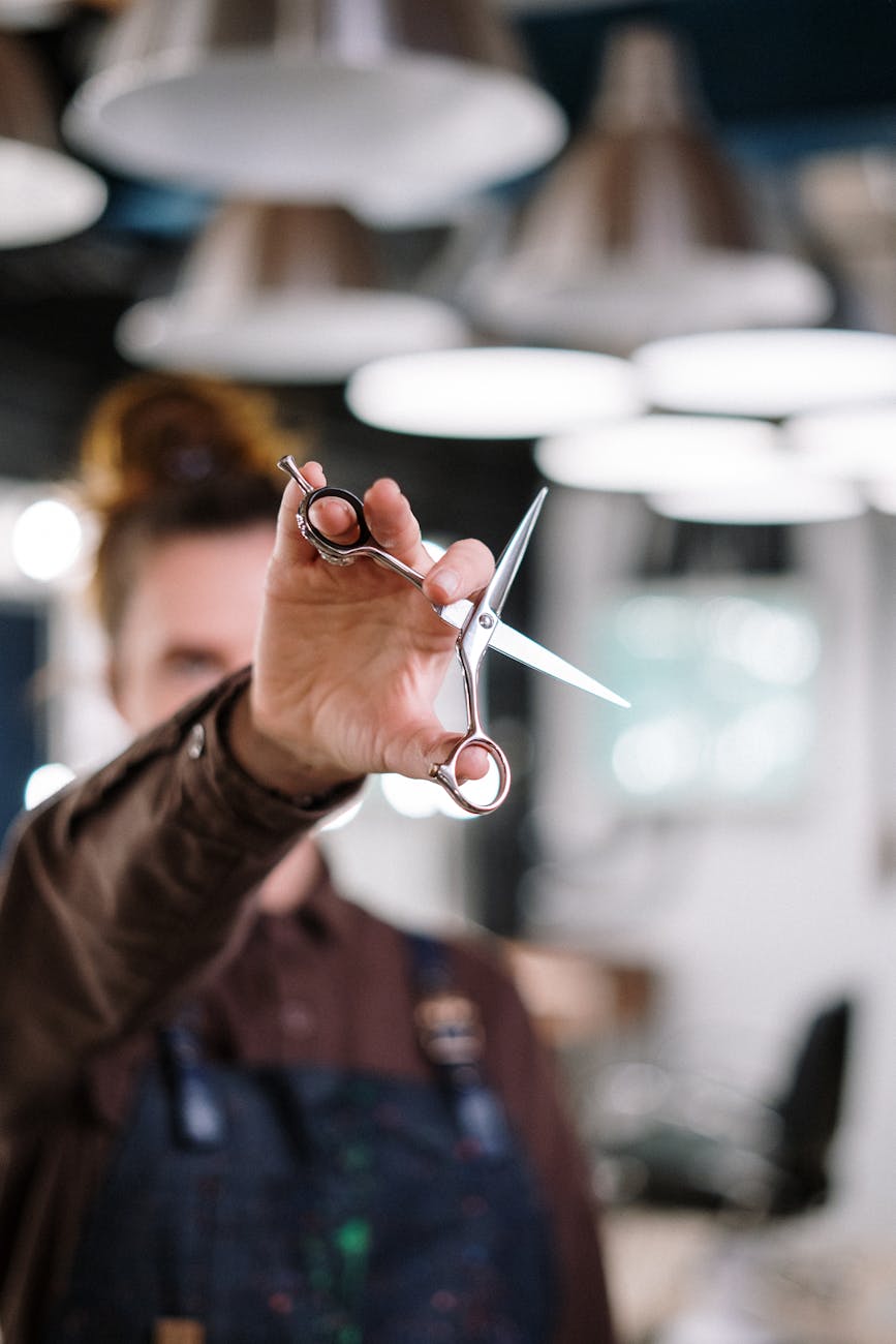 Close-up of a hairstylist holding scissors in a modern salon