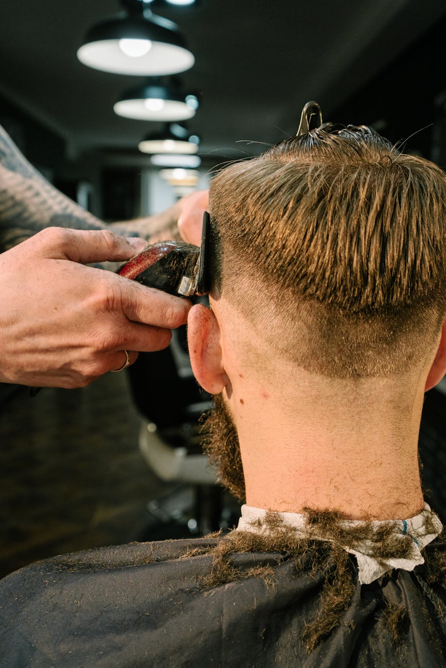 Barber cutting men's hair with clippers