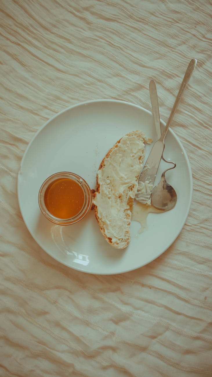 Toasted sourdough with ricotta and honey on a ceramic plate.